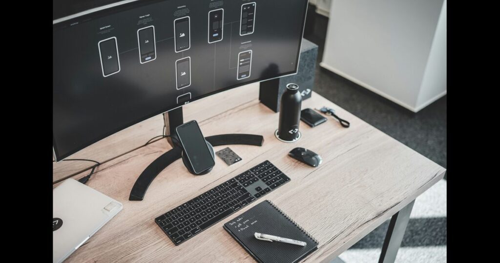 A desk with arious commuication devices including laptop, mobile devices