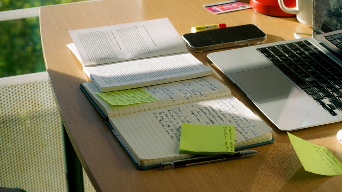 Desk with list post-it notes, list of to-do, and mobile devices