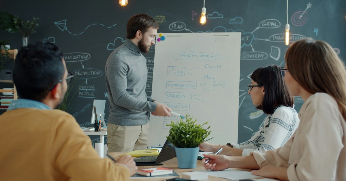 A guy pitching some work ideas in front of his office mates