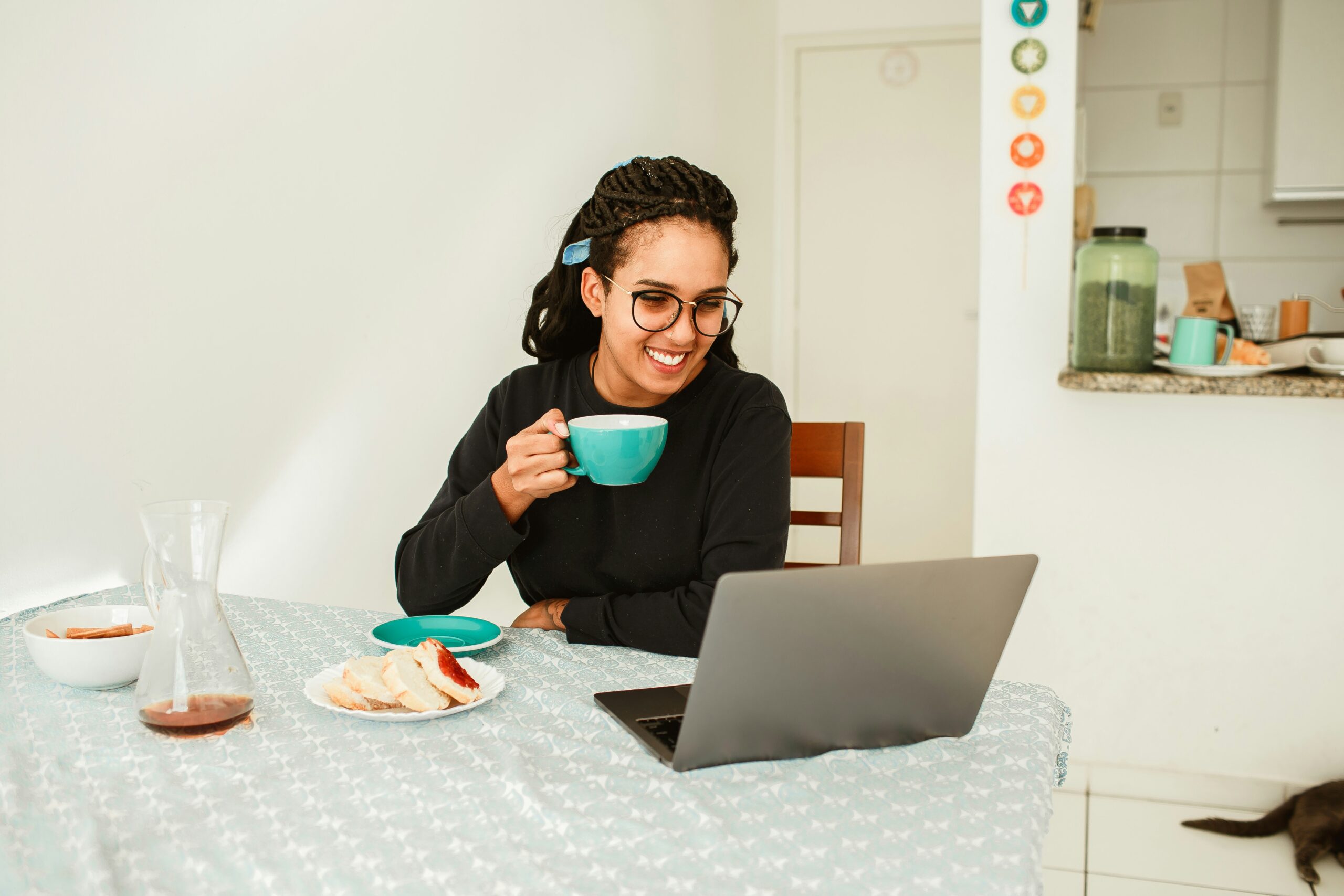 Working blissfully from home, a girl holds her coffee mug, radiating comfort and contentment - VirtualPro Solutions